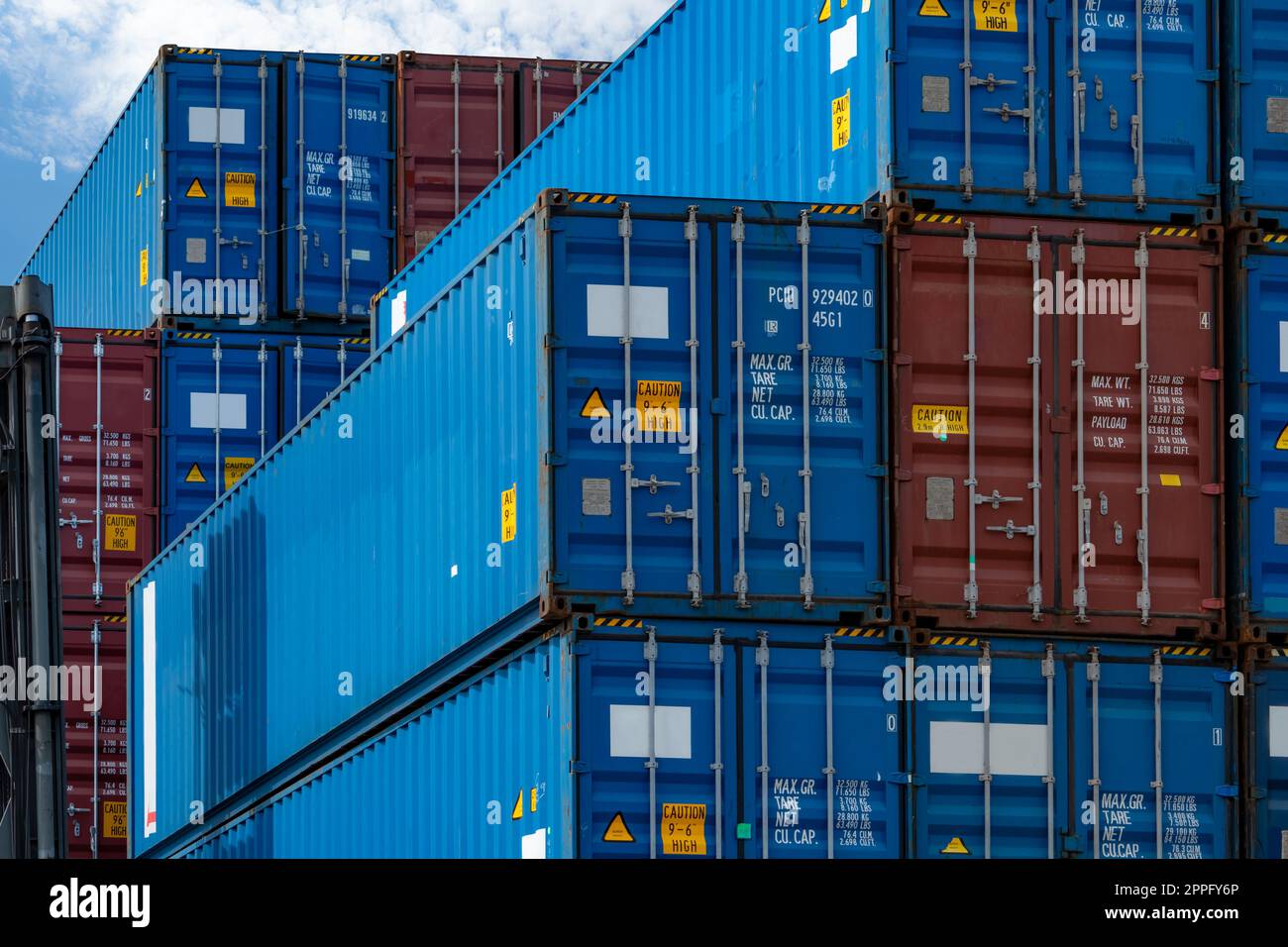 Blauer und roter Logistikcontainer für Nahaufnahmen. Fracht- und Schifffahrtsunternehmen. Containerversand für Import- und Exportlogistik. Logistikbranche. Container für Lkw-Transport. Frachttransportkonzept. Stockfoto