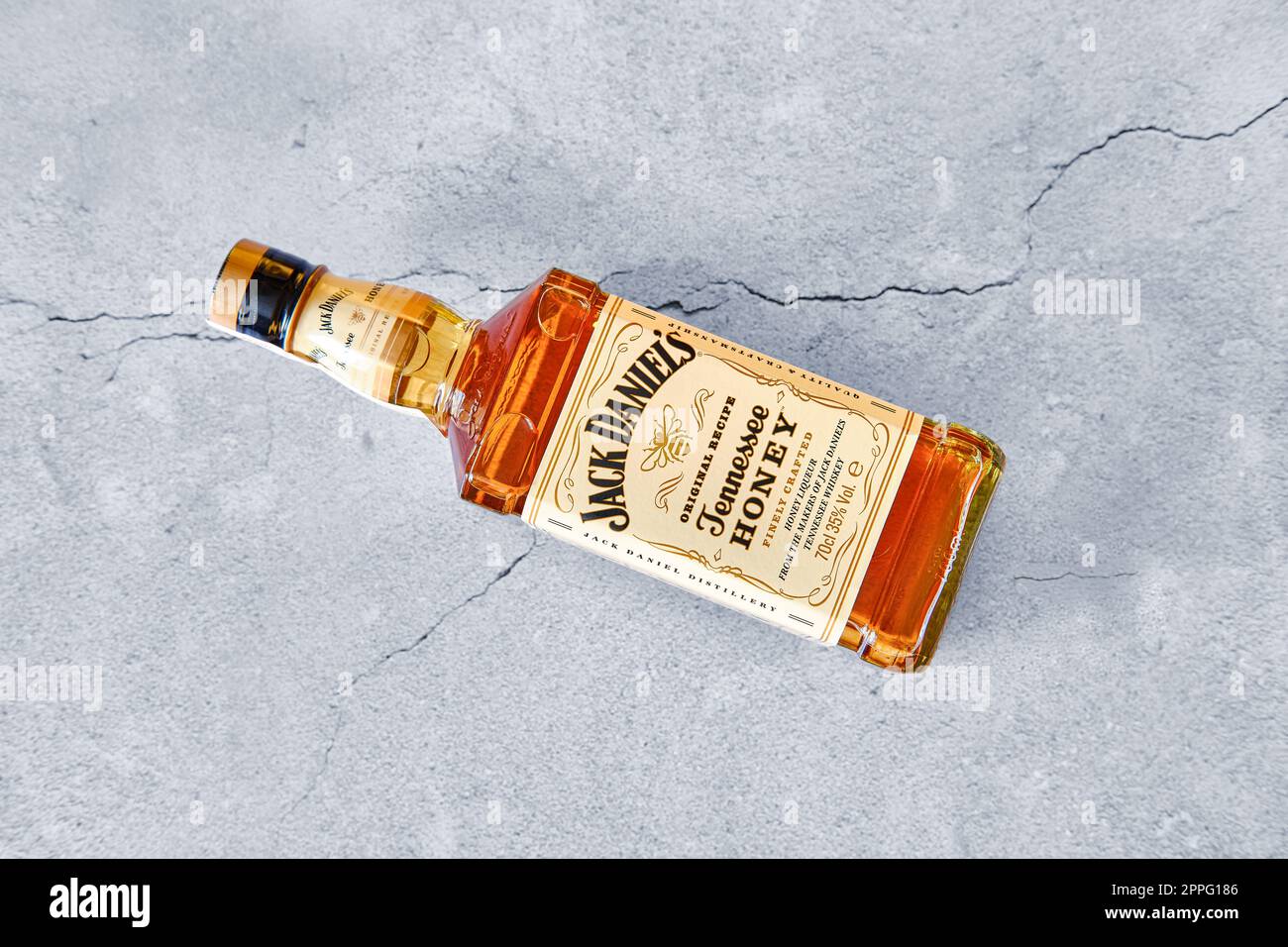 13. April 2021, Minsk, Belarus - Flasche Jack Daniel's Honey auf gerissenem Betonhintergrund Stockfoto