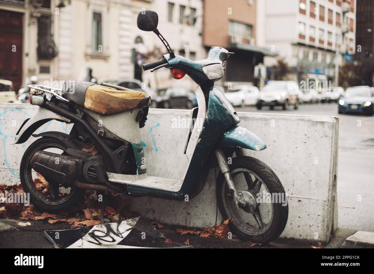 Ein altes Motorrad, rostig und kaputt, verlassen mitten in der Stadt. Stockfoto