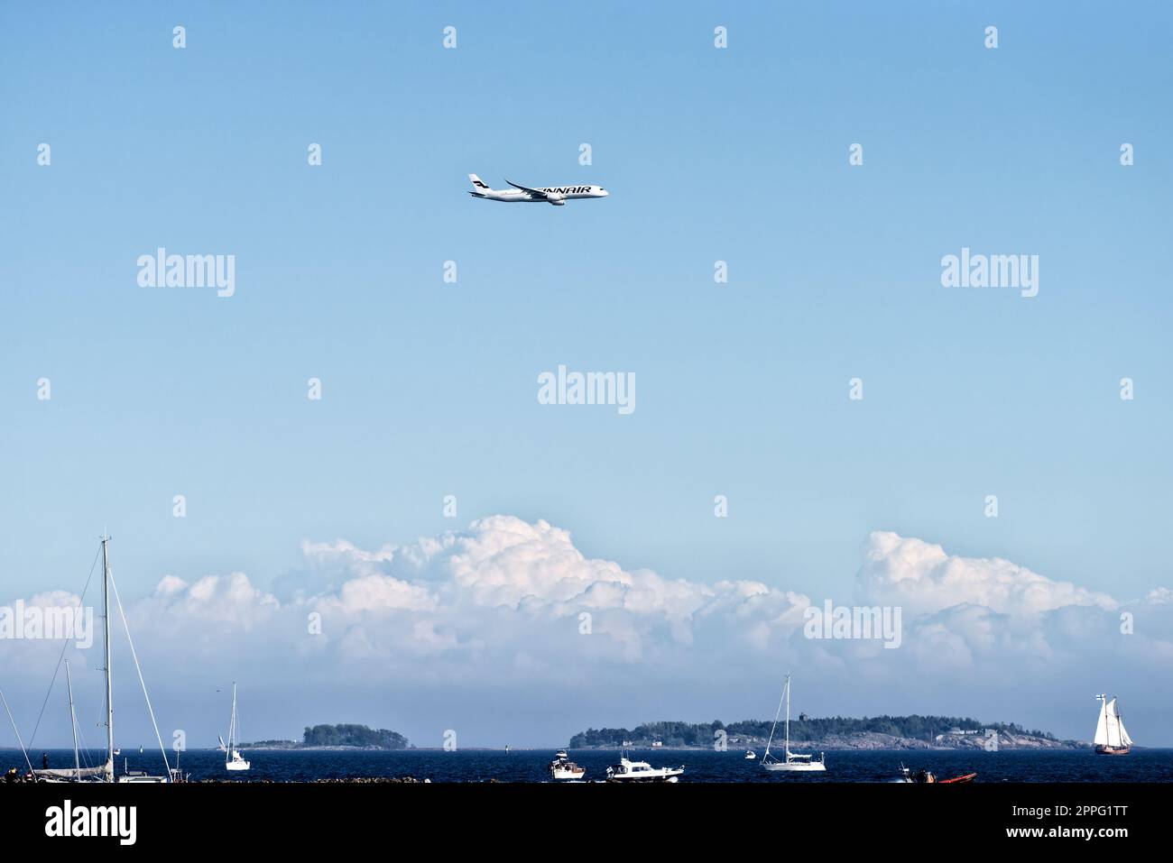 Helsinki, Finnland - 9. Juni 2017: Finnair Airbus A350 XWB-Flugzeug fliegt in extrem niedriger Höhe über der Inselgruppe von Helsinki mit Booten auf der for Stockfoto