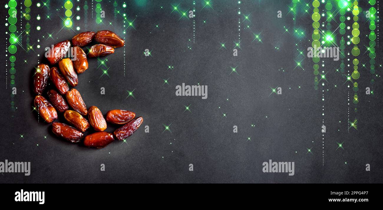 Ramadan Kareem mit Dattelfrüchten in Form eines Halbmonds auf schwarzem Hintergrund mit grünen, verschwommenen Sternen und Banner. Muslimischer traditioneller Iftar foo Stockfoto
