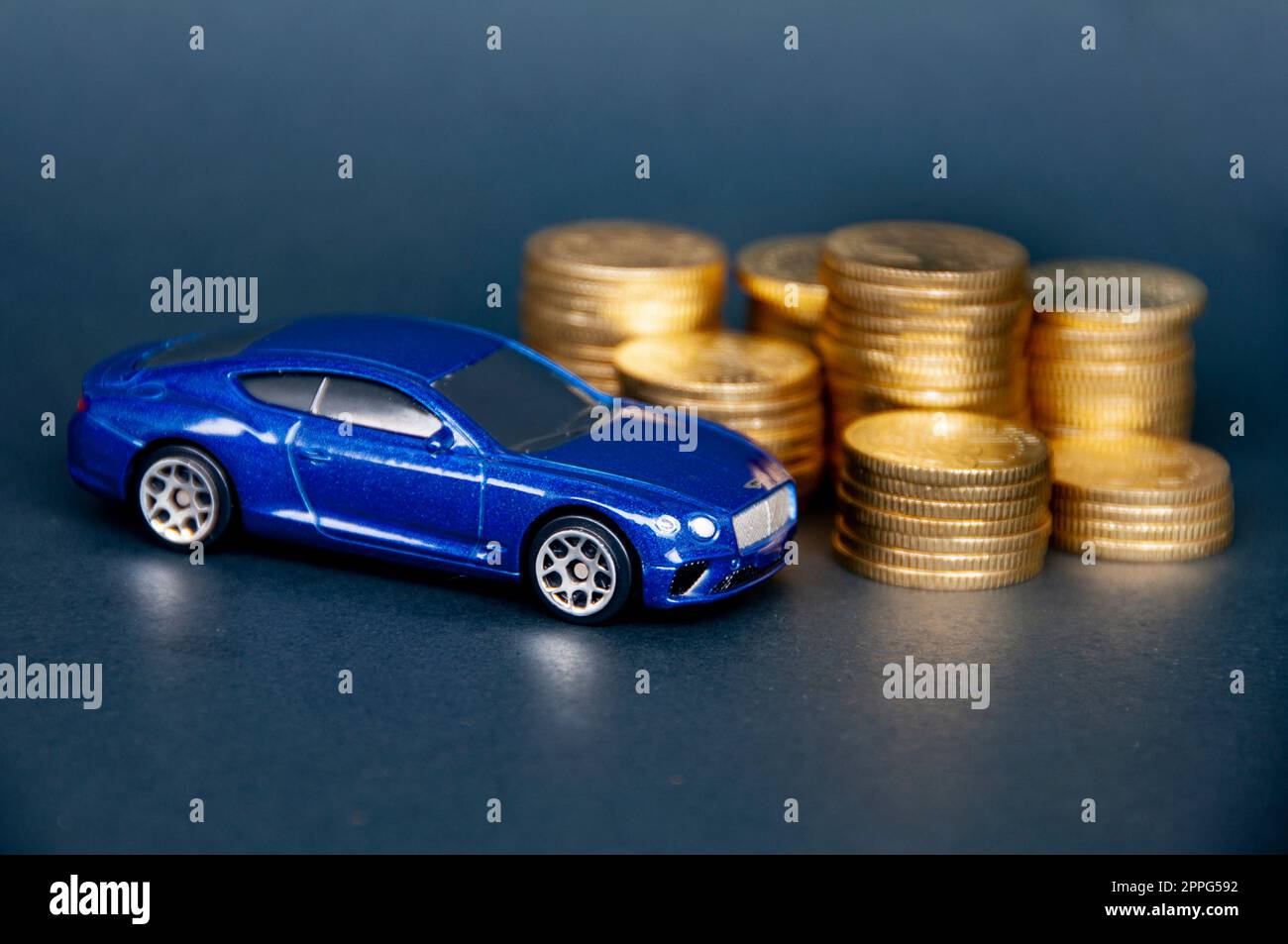 Kuala Lumpur, Malaysia - Juli 2022 : Miniatur-Spielzeugauto von Bentley Continental GT mit Goldmünzen auf schwarzem Überzug. Stockfoto