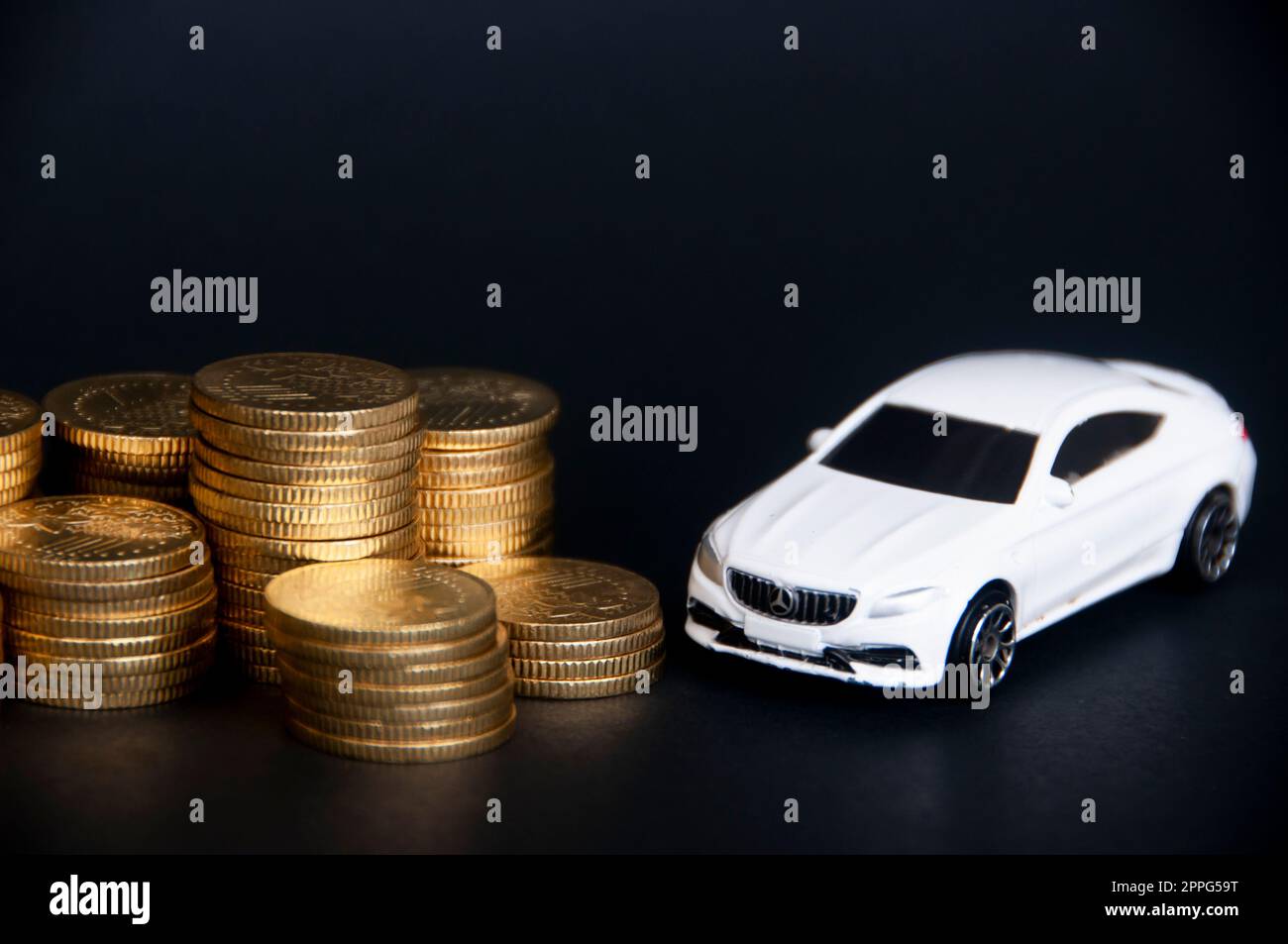 Kuala Lumpur, Malaysia - Juli 2022 : Miniatur-Spielzeugauto des Mercedes AMG mit Goldmünzen auf schwarzem Deckmantel. Stockfoto