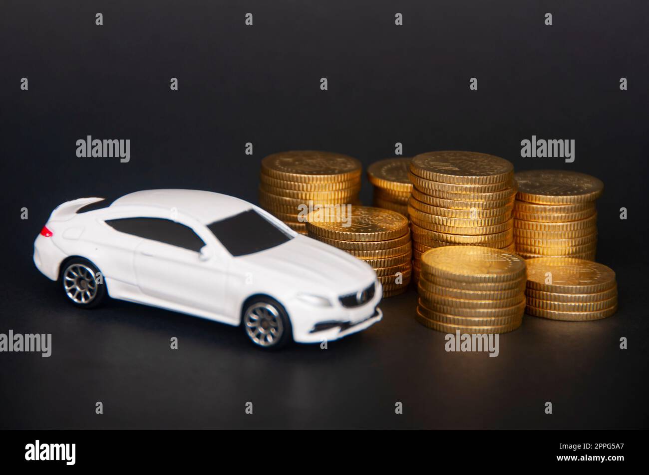 Kuala Lumpur, Malaysia - Juli 2022 : Miniatur-Spielzeugauto von Mercedes AMG mit Goldmünzen auf schwarzem Deckblatt. Speicherplatz kopieren Stockfoto
