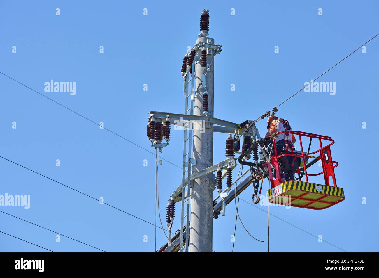 Freileitungsmonteur bei der Arbeit auf einem Strommasten, OberÃ¶sterreich - Arbeiter an einem Pol, Oberösterreich Stockfoto