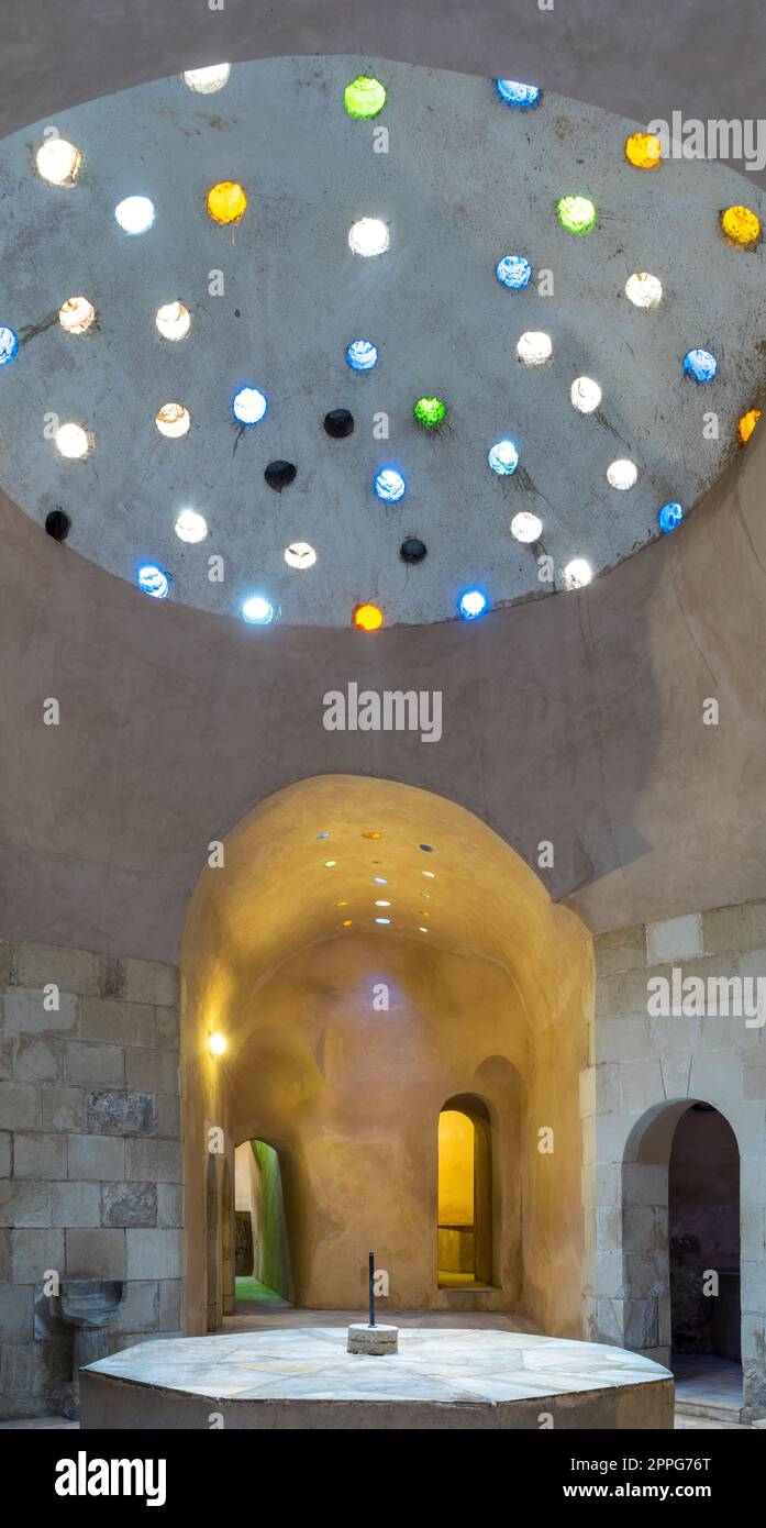 Gewölbte Steinwand, beleuchtet von Glasdachlöchern in einem historischen, traditionellen türkischen öffentlichen Bad Stockfoto