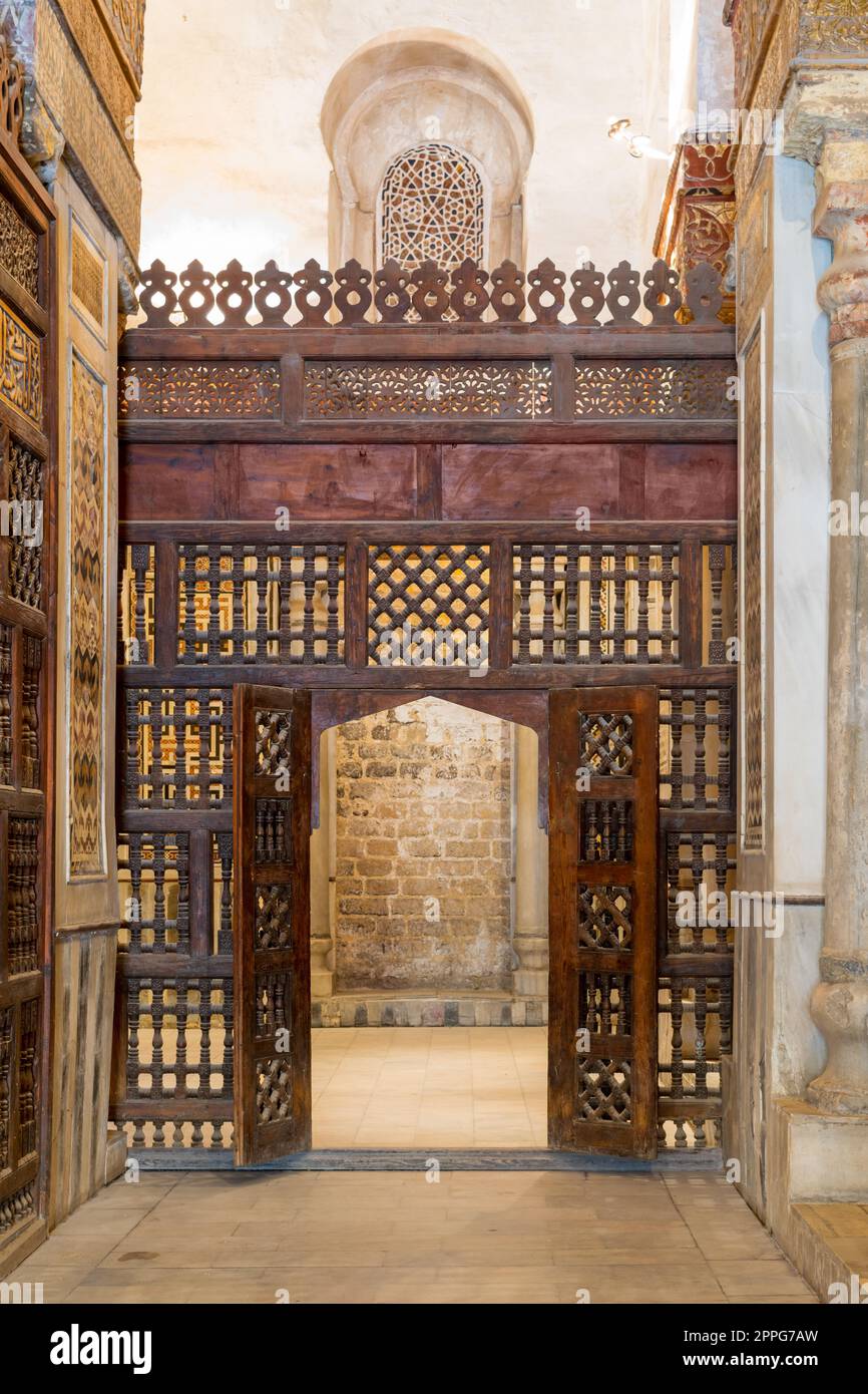 Verblüffende Holzwand, auch bekannt als Mashrabiya, mit kunstvoll verzierter Holztür Stockfoto