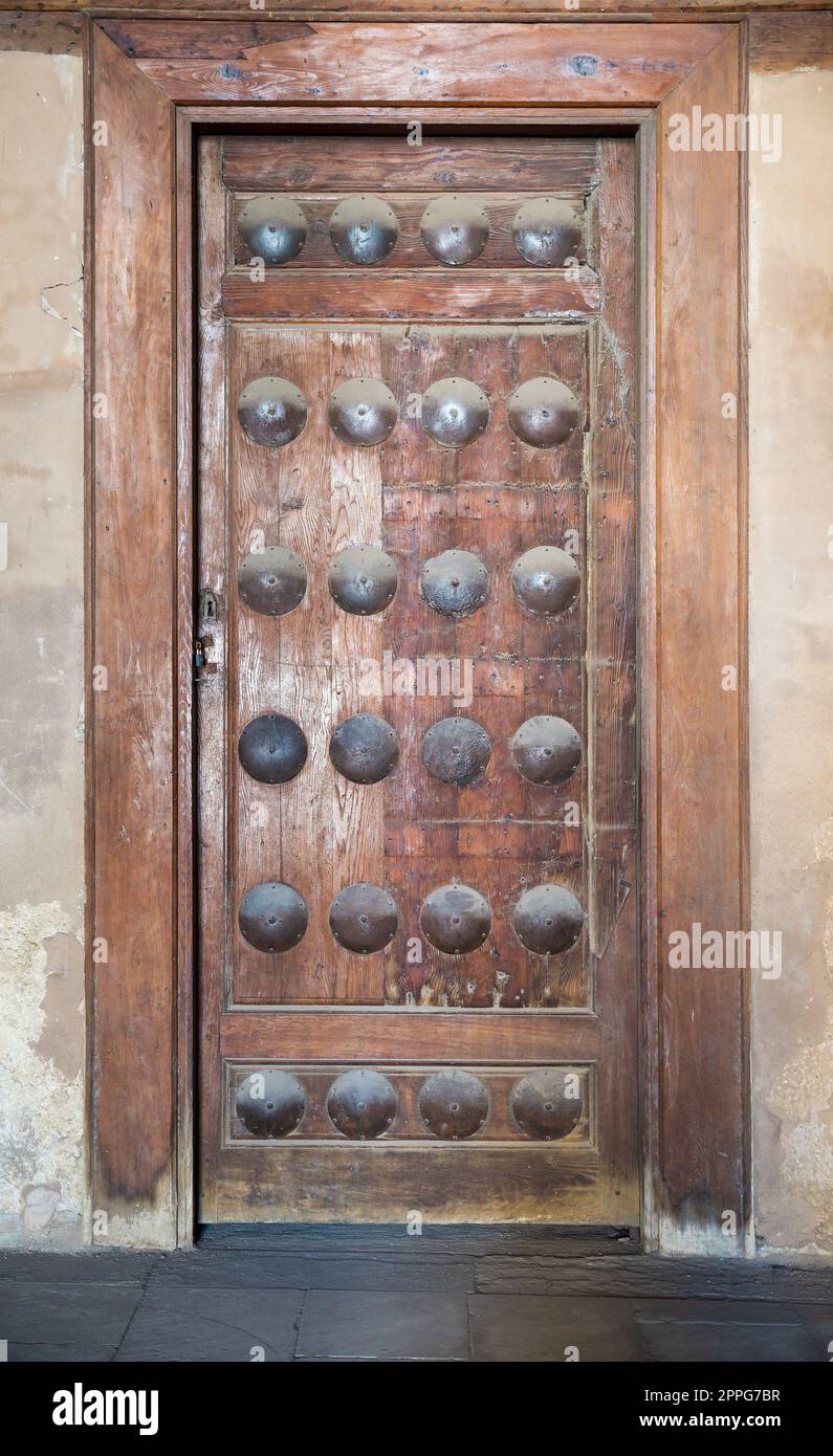 Grunge-Holztür an Grunge-Steinwand Stockfoto