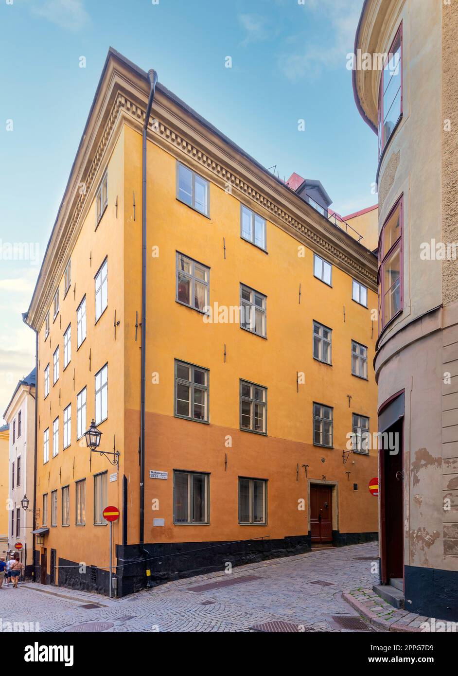 Alte orangefarbene Gebäude in engen Gassen mit Kopfsteinpflasterböden in Gamla Stan, der Altstadt von Stockholm, Schweden Stockfoto