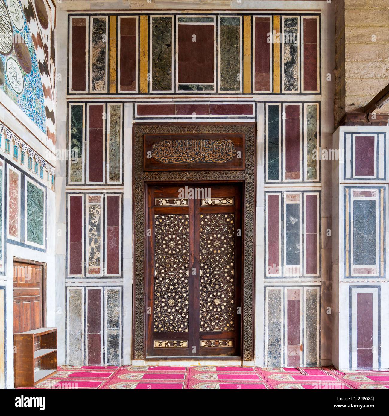 Alte, farbenfrohe Marmorwand mit Holztür, dekoriert mit arabischen Ornamenten, Kairo, Ägypten Stockfoto