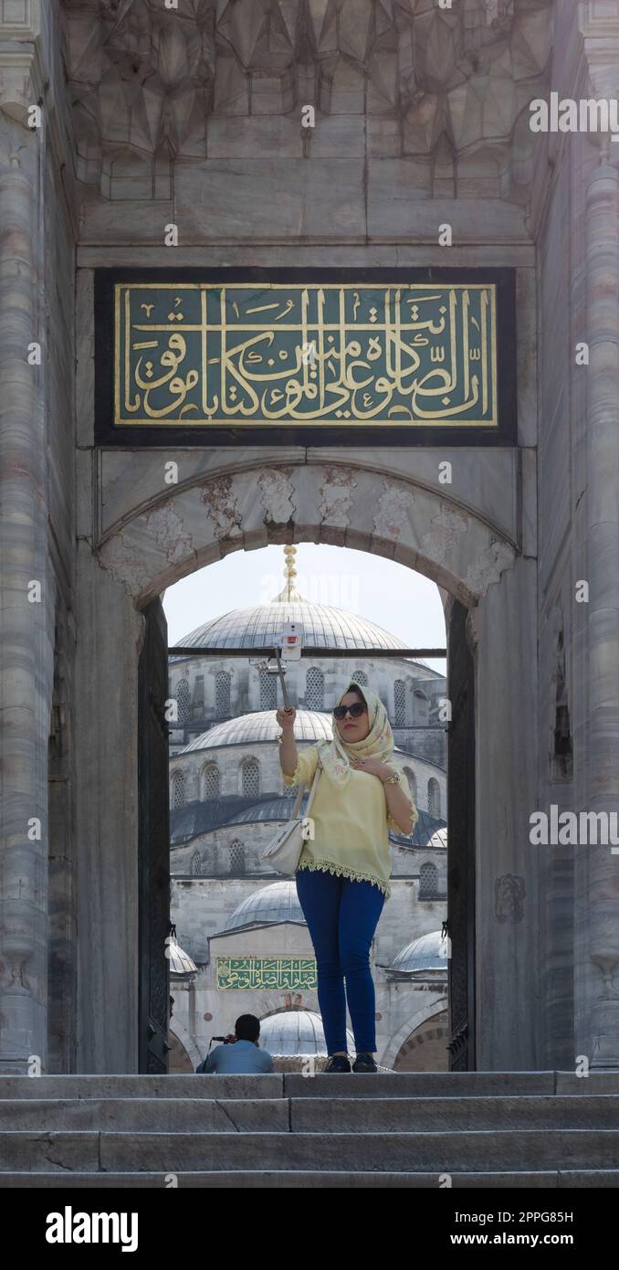 Weibliche Touristen machen ein Selfie-Foto vor einem der Eingänge der Blauen Moschee, Istanbul, Türkei Stockfoto