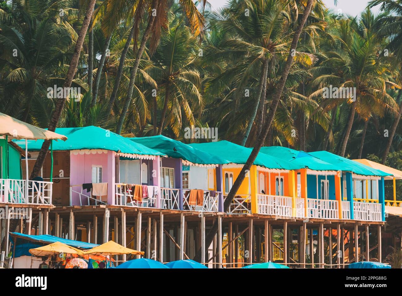 Canacona, Goa, Indien. Berühmte bemalte Gästehäuser am Strand von Ð¿ vor dem Hintergrund hoher Palmen am sonnigen Tag Stockfoto