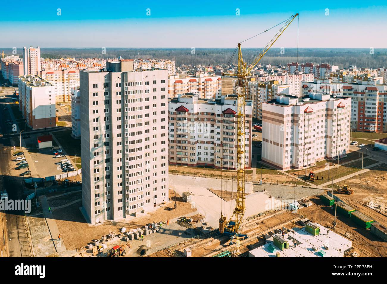 Gomel, Weißrussland. Der Baukran ist am Bau eines neuen mehrstöckigen Wohngebäudes beteiligt. Mehrstöckige Häuser Aus Der Vogelperspektive. Immobilien Hochhäuser. Entwicklungsindustrie. Stockfoto