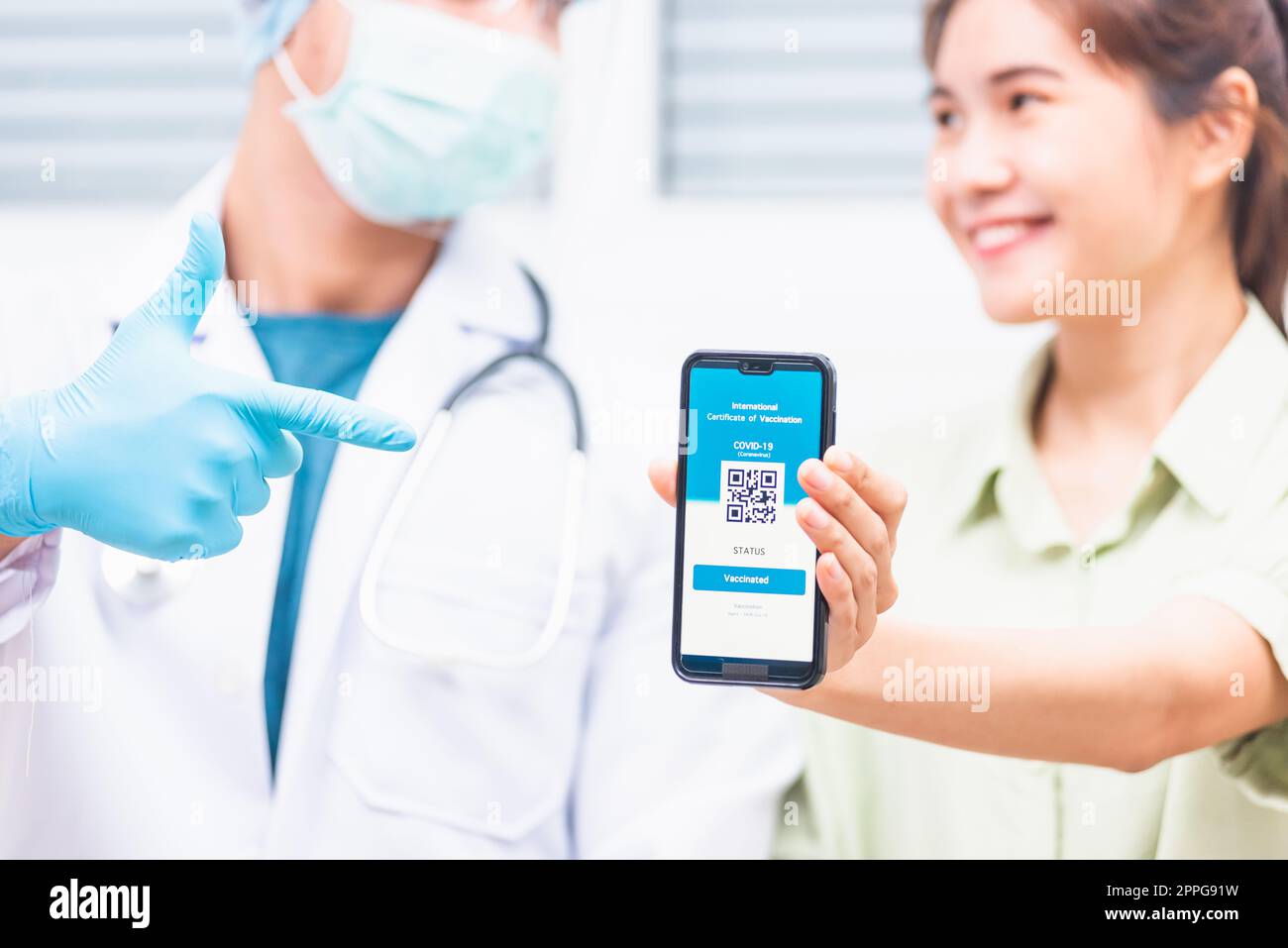 Frau in medizinischer Maske zeigen App Smartphone mobile Digital Screen geimpfte Coronavirus (COVID-19) Zertifikat nach Erhalt des Impfstoffs Stockfoto