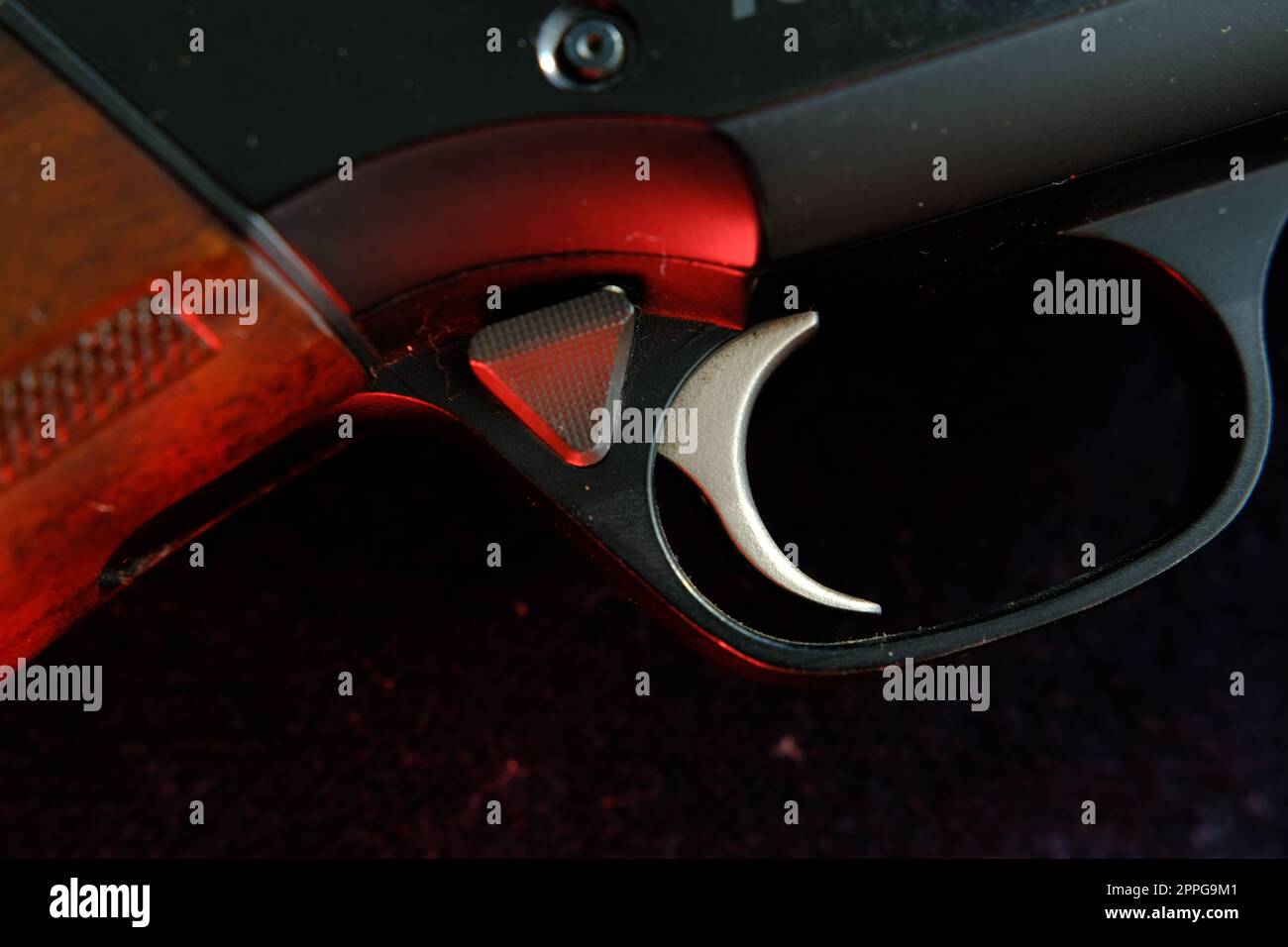 Auslöser eines Gewehrs auf schwarzem Hintergrund mit rotem Blitz Stockfoto