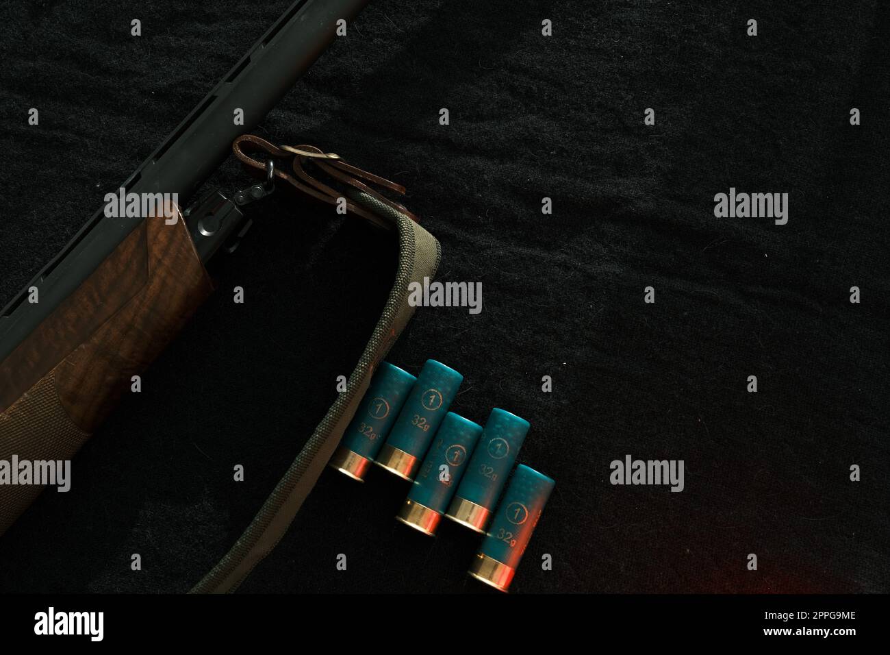 Waffe auf schwarzem Tuch: Gewehr, Muscheln, Draufsicht. Draufsicht auf Gewehr, Muscheln auf schwarzem Stoffhintergrund Stockfoto