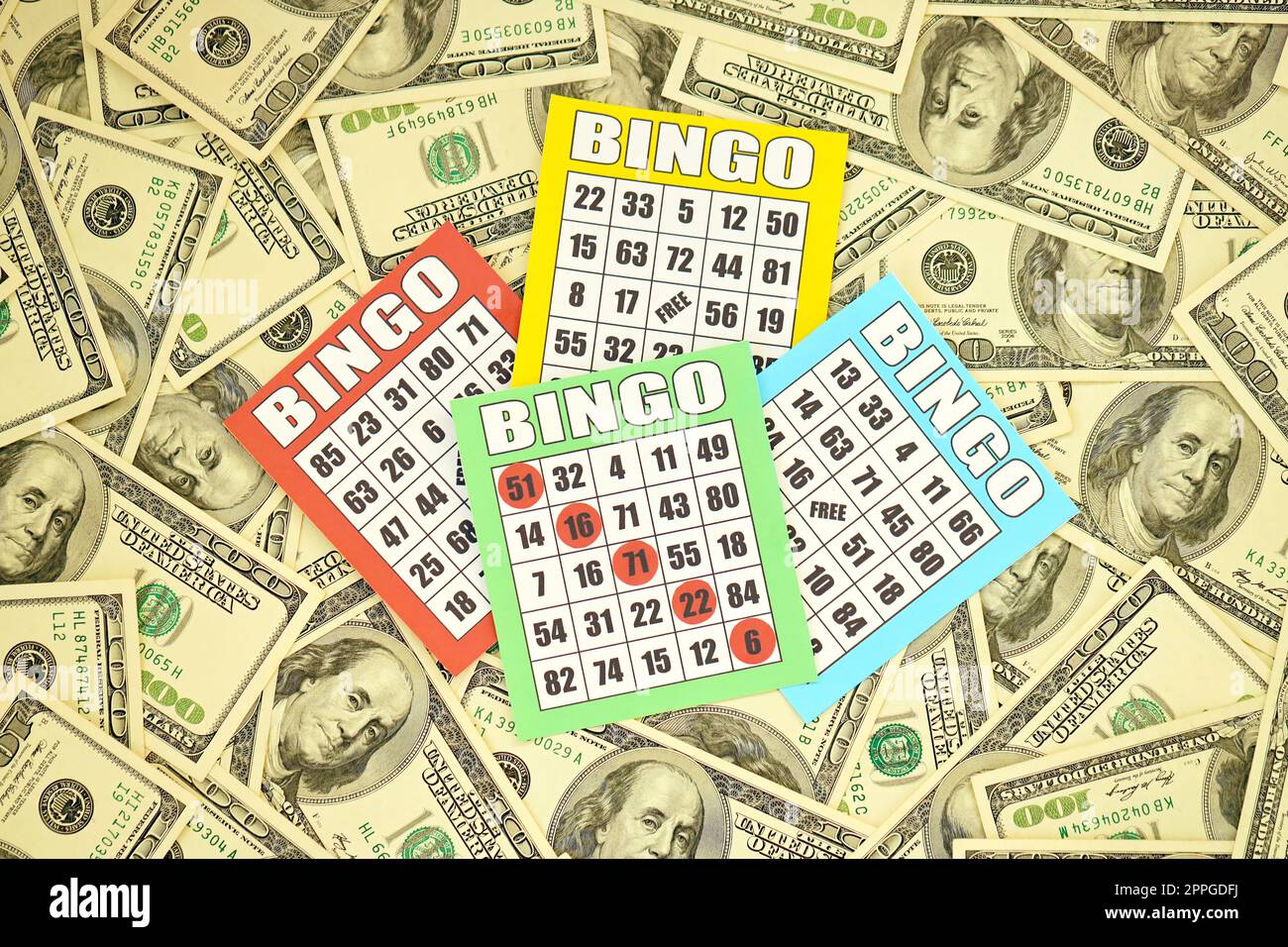 Viele Bingo-Boards oder Spielkarten, um Chips und eine große Menge Dollarscheine zu gewinnen. Klassische amerikanische oder kanadische fünf bis fünf Bingo-Karten auf Geld Stockfoto