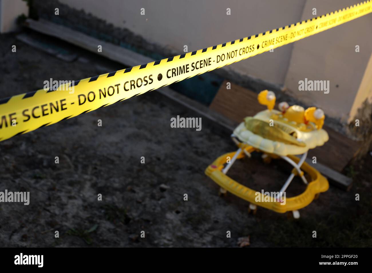Tatortband für die Absperrung der Gegend. Gelbes Band mit verschwommenem forensischen Hintergrund in Kinoatmosphäre Stockfoto