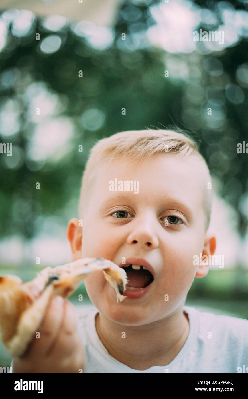 Little Boy Isst Pizza Im Café Am Sommertag Stockfoto