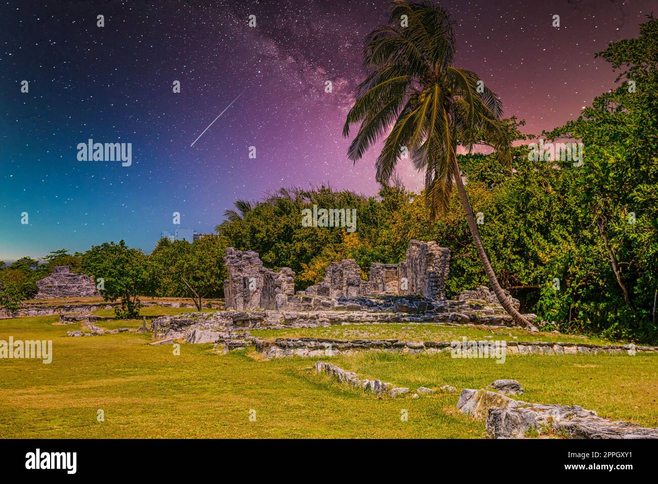 Iguana-Eidechse in den alten Ruinen der Maya in der archäologischen Zone El Rey bei Cancun, Yukatan, Mexiko mit dem Nachthimmel der Milchstraße-Galaxie Stockfoto