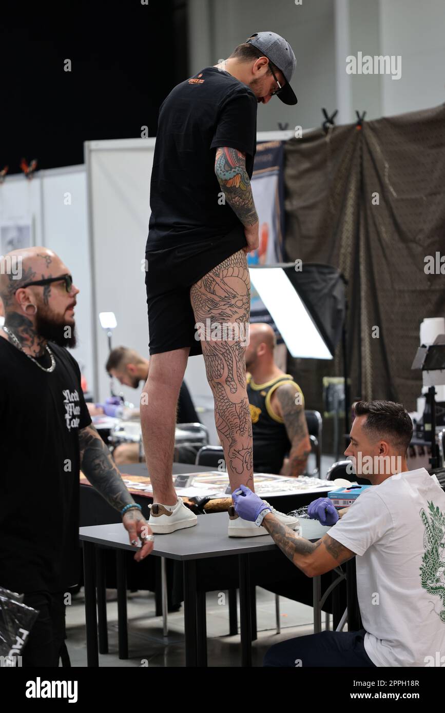 Nicht identifizierter Teilnehmer bei der 15. Tattoofest Convention in Krakau. Tattoo-Künstler bei der Arbeit. Stockfoto