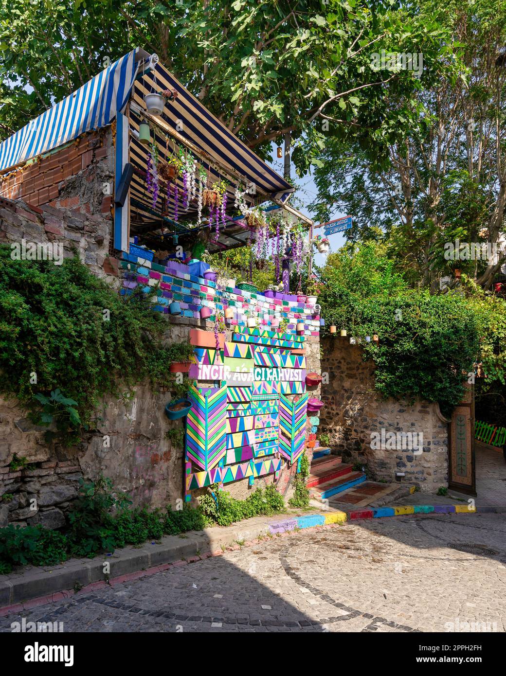 Tagsüber gibt es ein Café mit bunten Paneelen, farbenfrohen Treppen und Balat District, Istanbul, Türkei Stockfoto