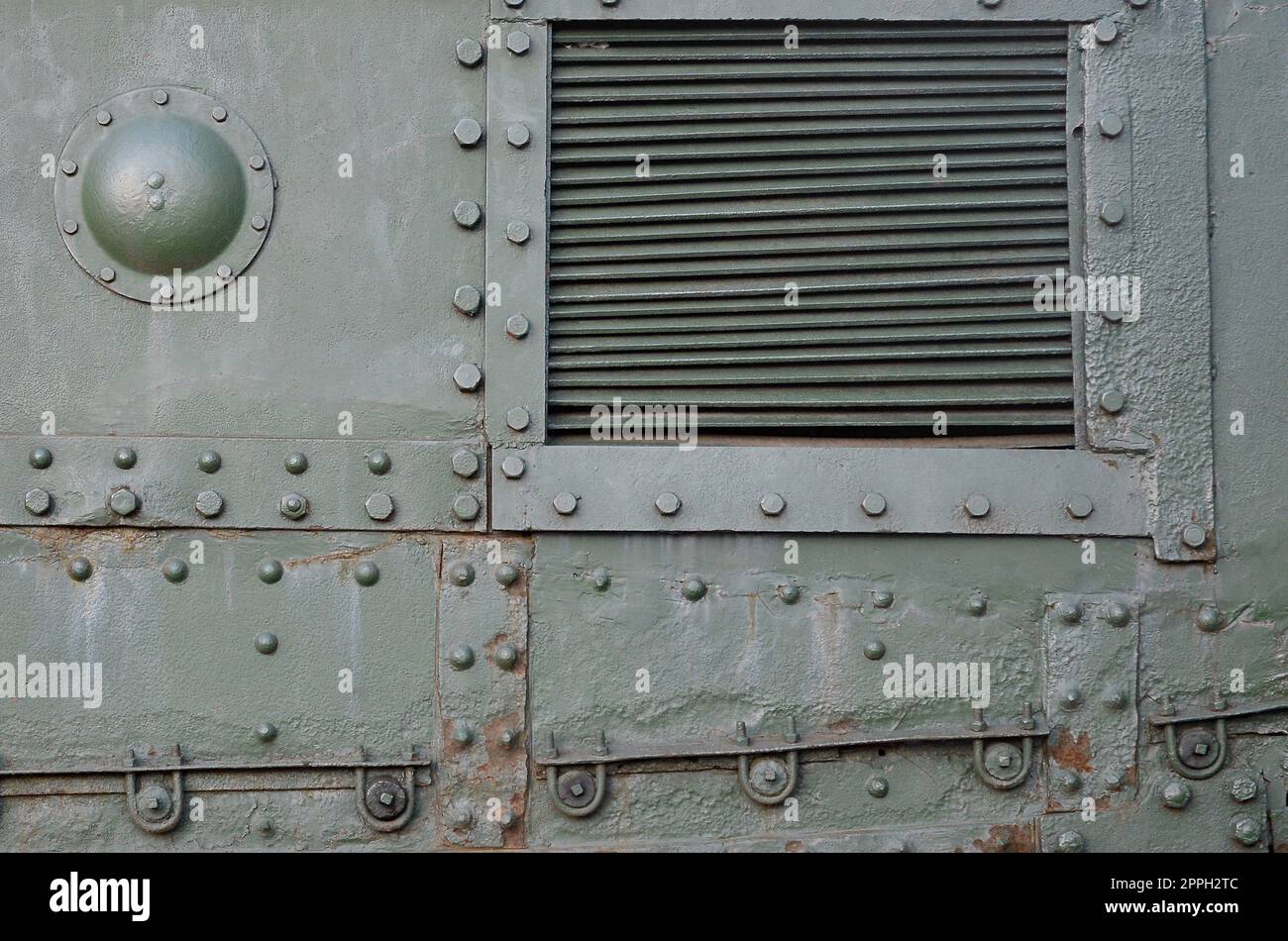 Struktur der Seitenwand des Tanks, aus Metall und mit einer Vielzahl von Schrauben und Nieten verstärkt Stockfoto