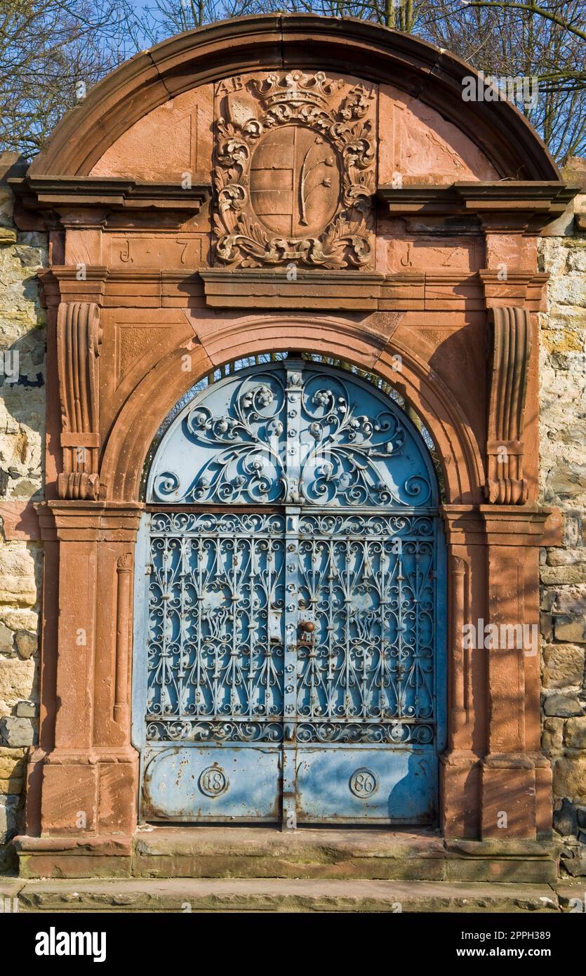 Geschlossenes, herrlich dekoriertes Tor mit einem Rahmen aus Sandstein Stockfoto