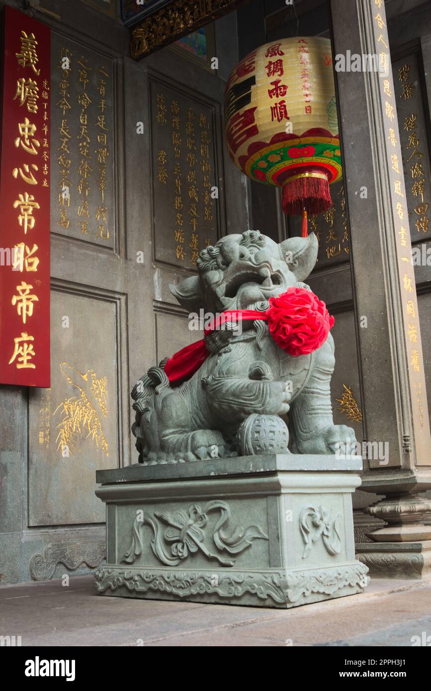 Chinesischer imperialer Schutzlöwe aus Stein, der das Tor in einem buddhistischen Tempel in Saigon, Vietnam (Ho-Chi-Minh-Stadt) bewacht Stockfoto