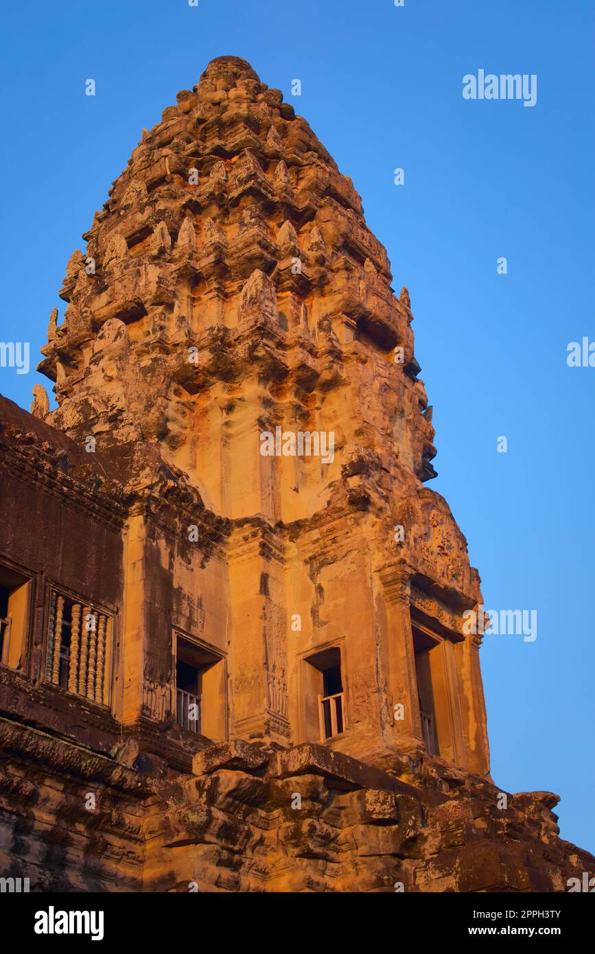 Angkor Wat, in Kambodscha. Niedriger Winkel Blick auf einen der zentralen Türme bei Sonnenuntergang vor blauem Himmel. Stockfoto
