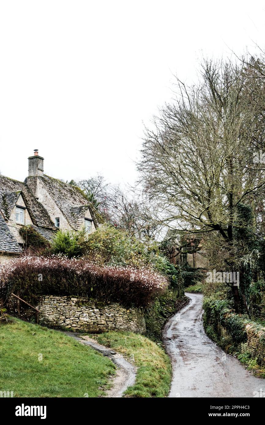 Gewundene Landstraße im Cotswold-Dorf Bibury, Glouctershire. Stockfoto