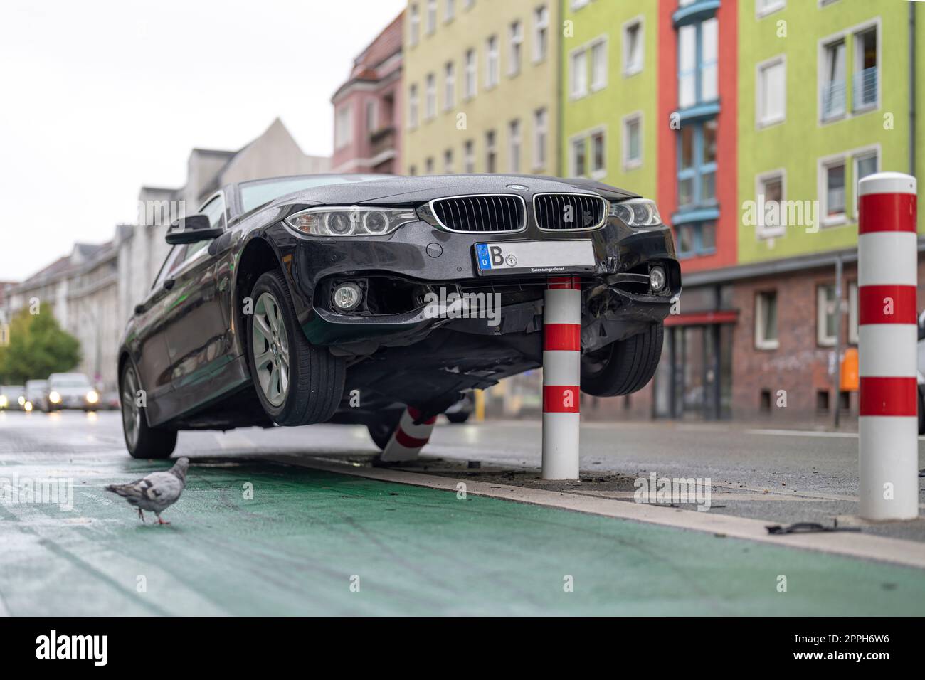 In den frühen Morgenstunden stieß ein Pkw auf die Poller einer Fahrradstrecke im verkehrsberuhigten HermannstraÃŸe (Geschwindigkeit 30 km/h) in Berlin und erlitt erhebliche Schäden am Unterboden und Motorraum. Der Fahrer floh und verließ das Fahrzeug Stockfoto