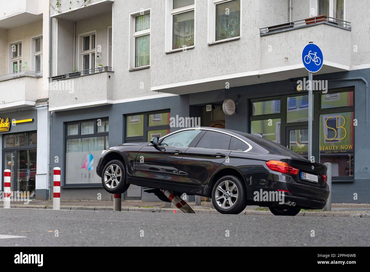 In den frühen Morgenstunden stieß ein Pkw auf die Poller einer Fahrradstrecke im verkehrsberuhigten HermannstraÃŸe (Geschwindigkeit 30 km/h) in Berlin und erlitt erhebliche Schäden am Unterboden und Motorraum. Der Fahrer floh und verließ das Fahrzeug Stockfoto