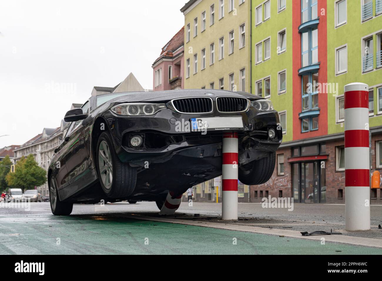 In den frühen Morgenstunden stieß ein Pkw auf die Poller einer Fahrradstrecke im verkehrsberuhigten HermannstraÃŸe (Geschwindigkeit 30 km/h) in Berlin und erlitt erhebliche Schäden am Unterboden und Motorraum. Der Fahrer floh und verließ das Fahrzeug Stockfoto