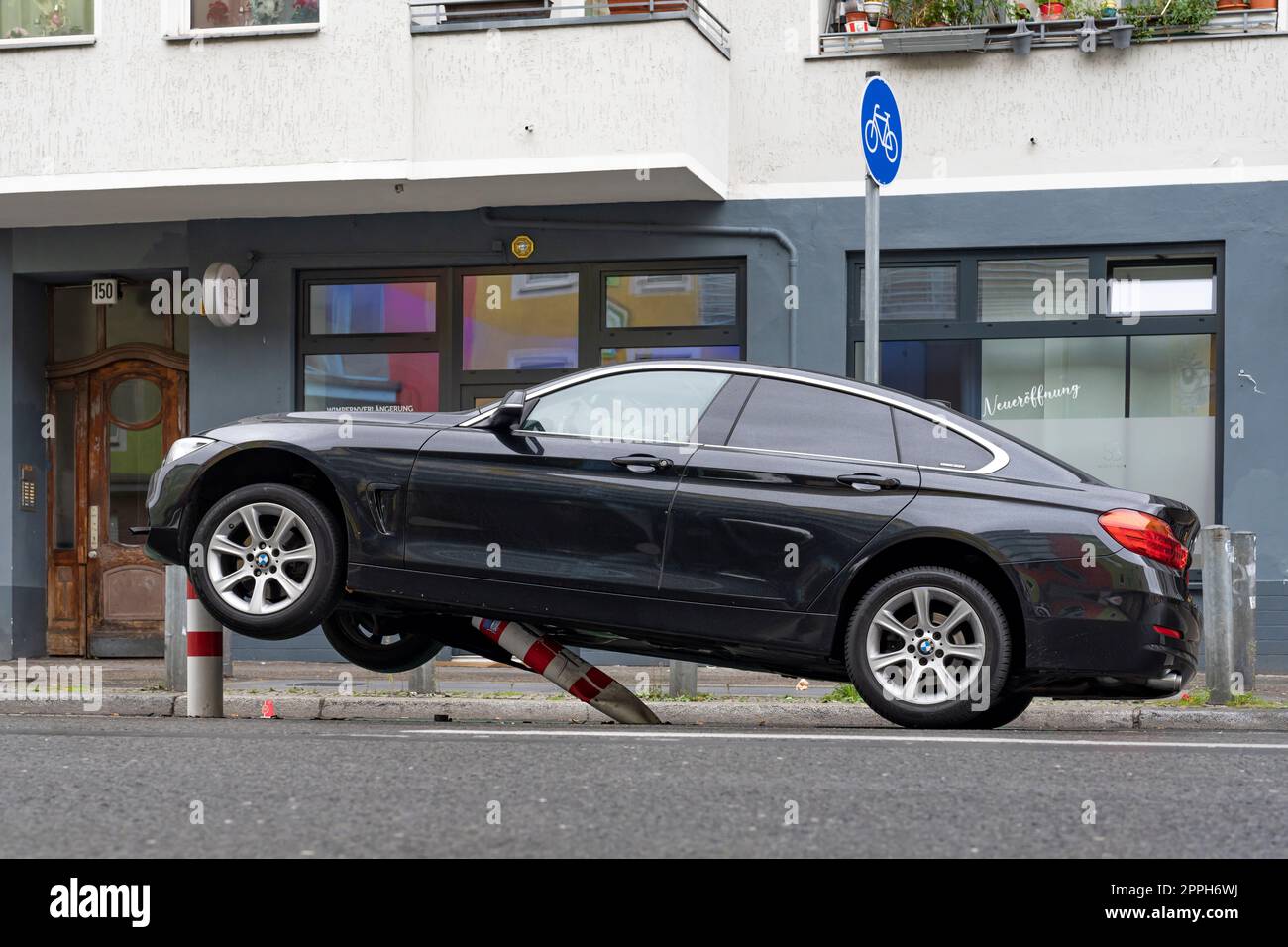 In den frühen Morgenstunden stieß ein Pkw auf die Poller einer Fahrradstrecke im verkehrsberuhigten HermannstraÃŸe (Geschwindigkeit 30 km/h) in Berlin und erlitt erhebliche Schäden am Unterboden und Motorraum. Der Fahrer floh und verließ das Fahrzeug Stockfoto