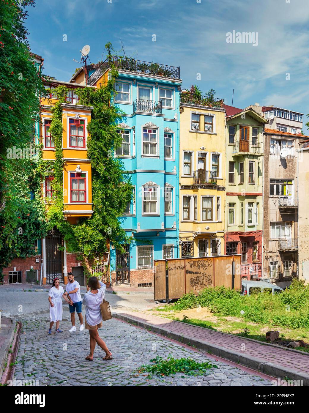 Traditionelle farbenfrohe alte Häuser im Balat-Viertel, mit Touristen, die im Sommer in Istanbul, der Türkei, Erinnerungsfotos machen Stockfoto