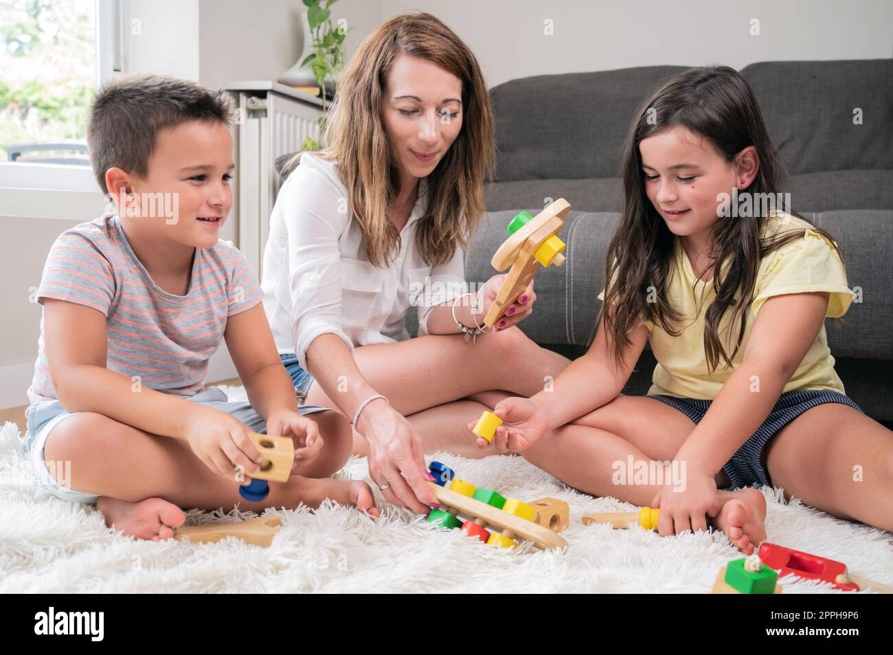Alleinerziehende Mutter, die zu Hause mit ihren Kindern spielt. Stockfoto