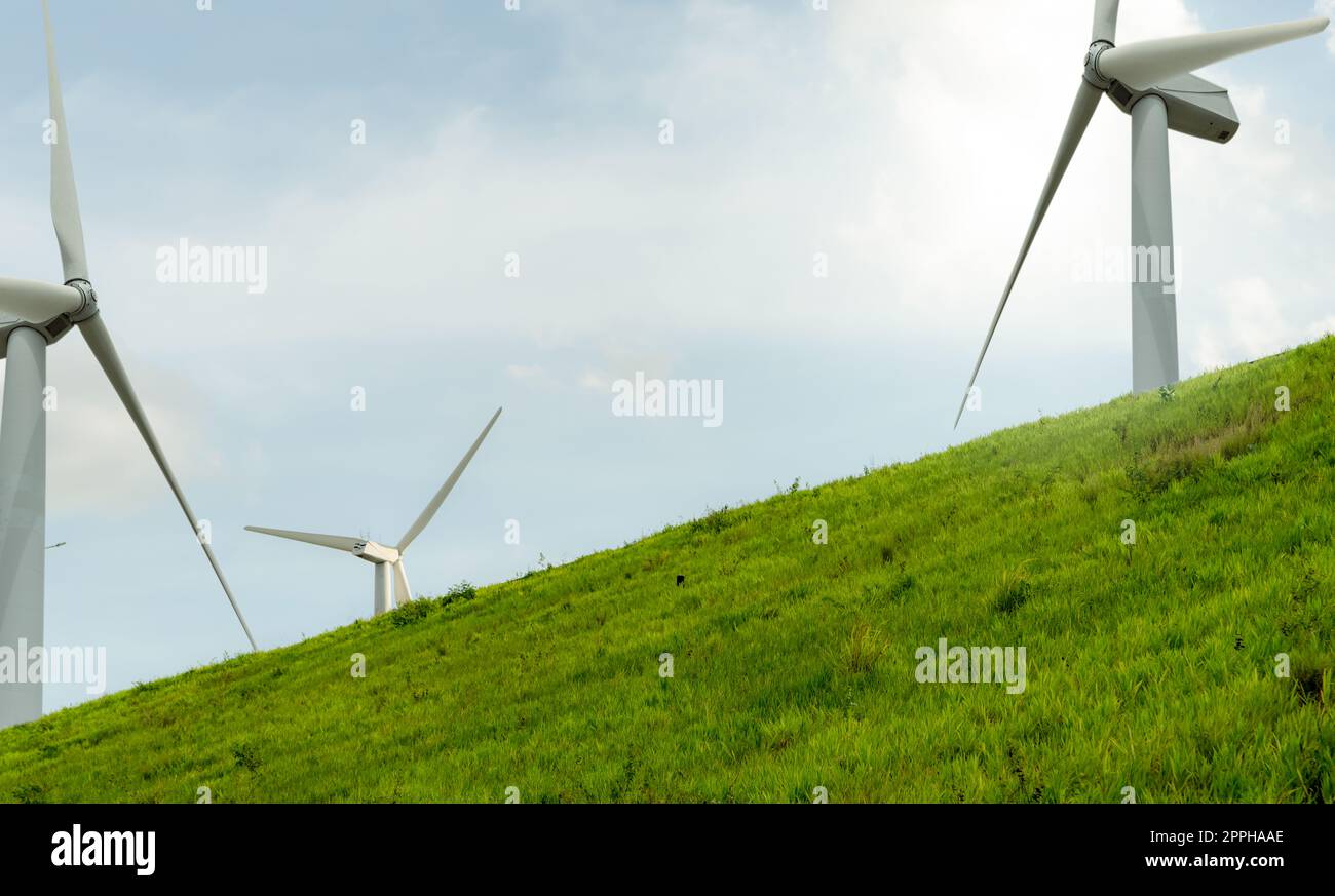 Windenergie. Windkraft. Nachhaltige, erneuerbare Energien. Windturbinen erzeugen Strom. Windmühlen-Farm auf einem Berg mit blauem Himmel. Umweltfreundliche Technologie. Erneuerbare Ressource. Nachhaltige Entwicklung. Stockfoto