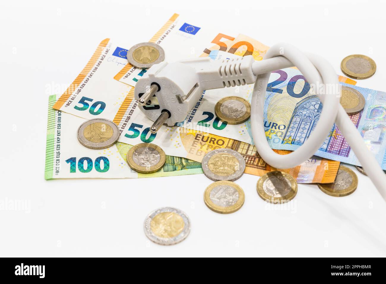 Das geknotete Stromkabel auf Euro-Banknoten und -Münzen. Konzept steigender Strompreise Stockfoto