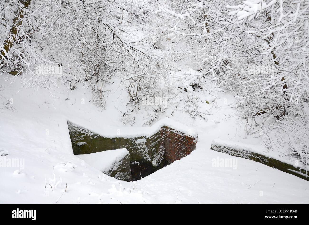 Unterirdischer Bunker alter Backsteinmauern im Winter nach Schneefall Stockfoto