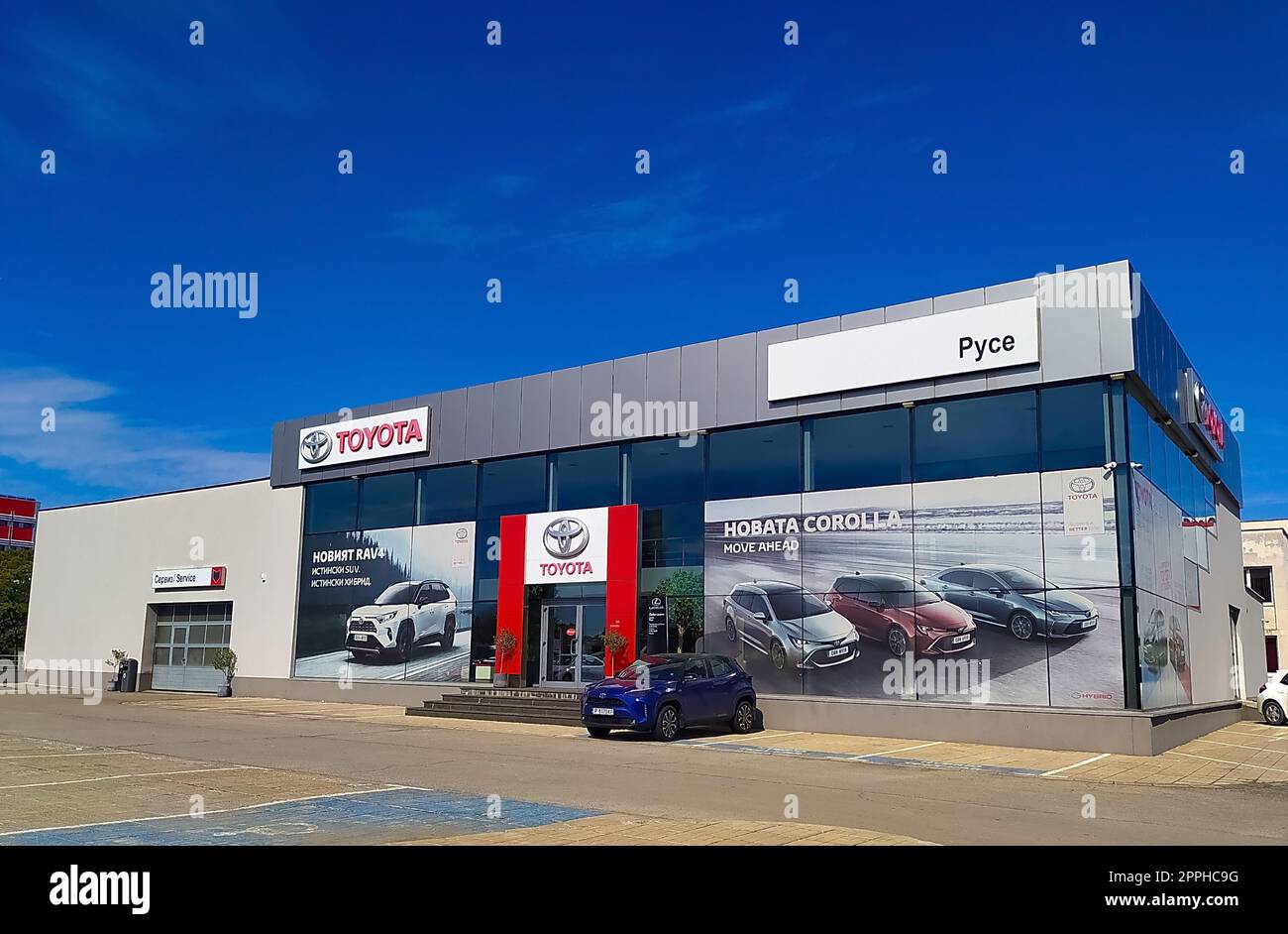 Ruse, Bulgarien - 25. September 2022: Fassade eines Autohändlers von Toyota mit dem Firmenlogo und dem Namen von Toyota in roten Buchstaben Stockfoto