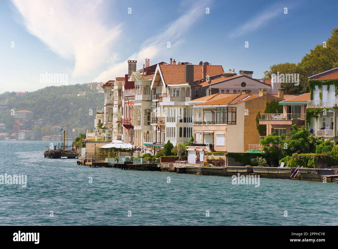 Traditionelle Häuser auf der europäischen Seite der Bosporus-Straße, Istanbul, Türkei, vor dem Hintergrund grüner Berge Stockfoto