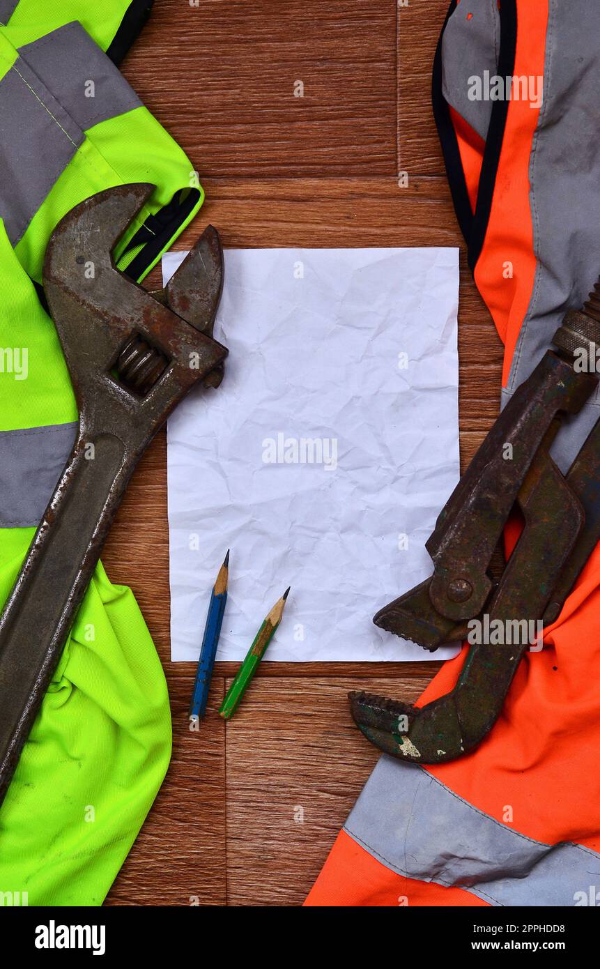 Ein zerknittertes Blatt Papier mit zwei Bleistiften, umgeben von einem grünen A. Stockfoto