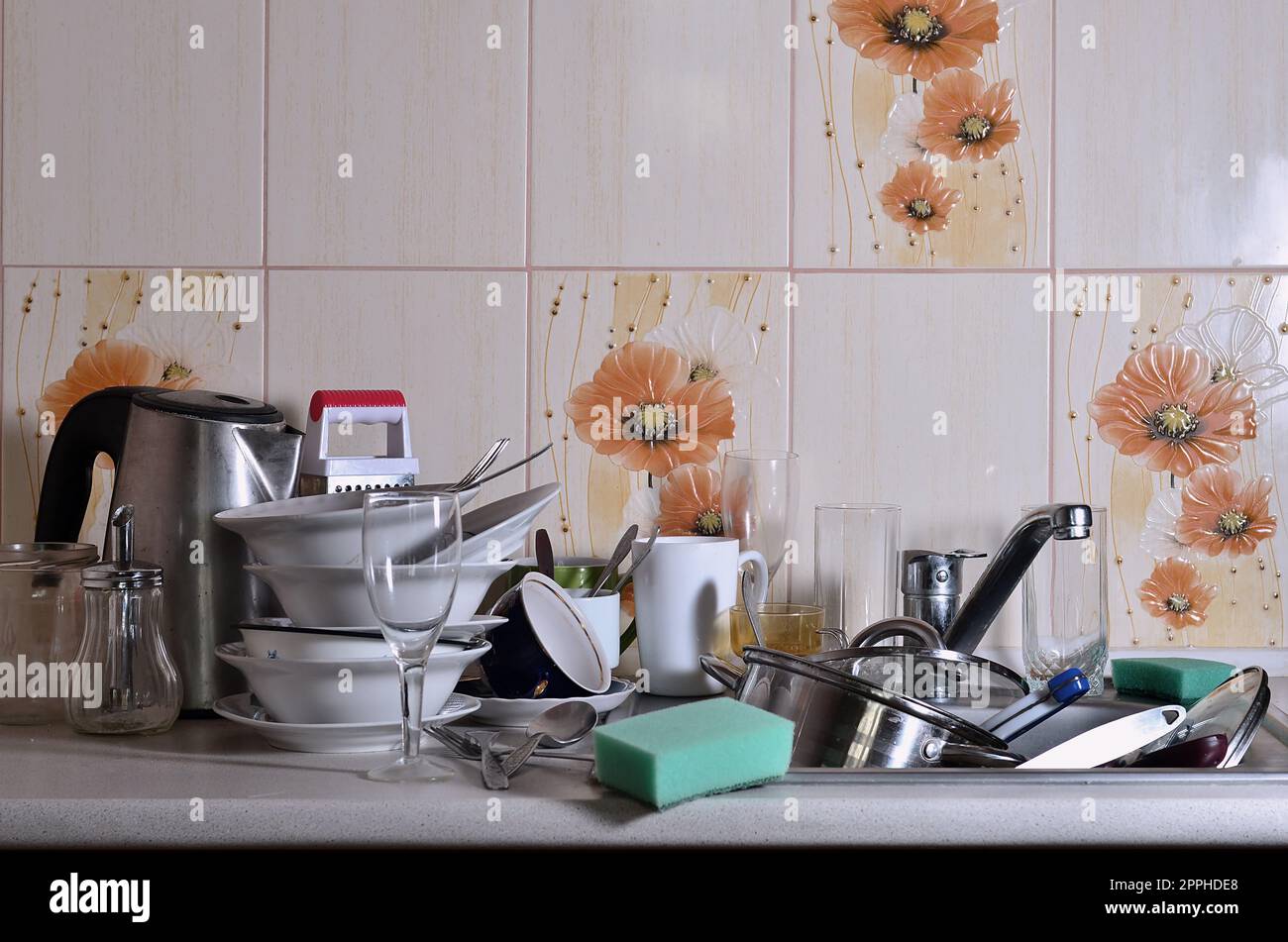 Ein riesiger Haufen ungewaschenes Geschirr im Spülbecken und auf der Arbeitsfläche Stockfoto