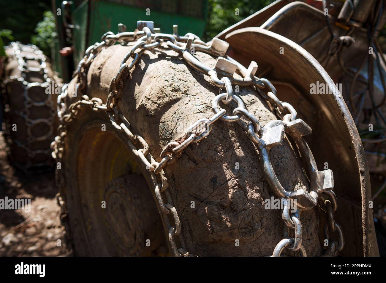 Traktionsketten auf dem großen Rad eines Holzstaplers Stockfoto