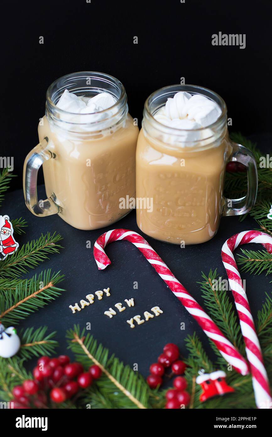 Eine Tasse Kaffee mit Marshmallows, Weihnachtsschmuck und Süßigkeiten. Stockfoto