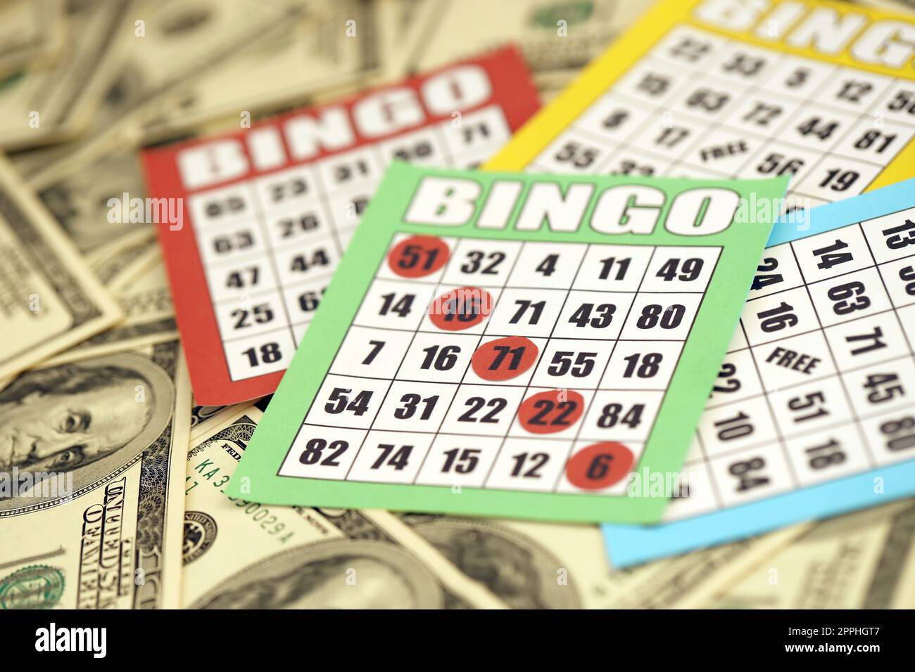 Viele Bingo-Boards oder Spielkarten, um Chips und eine große Menge Dollarscheine zu gewinnen. Klassische amerikanische oder kanadische fünf bis fünf Bingo-Karten auf Geld Stockfoto