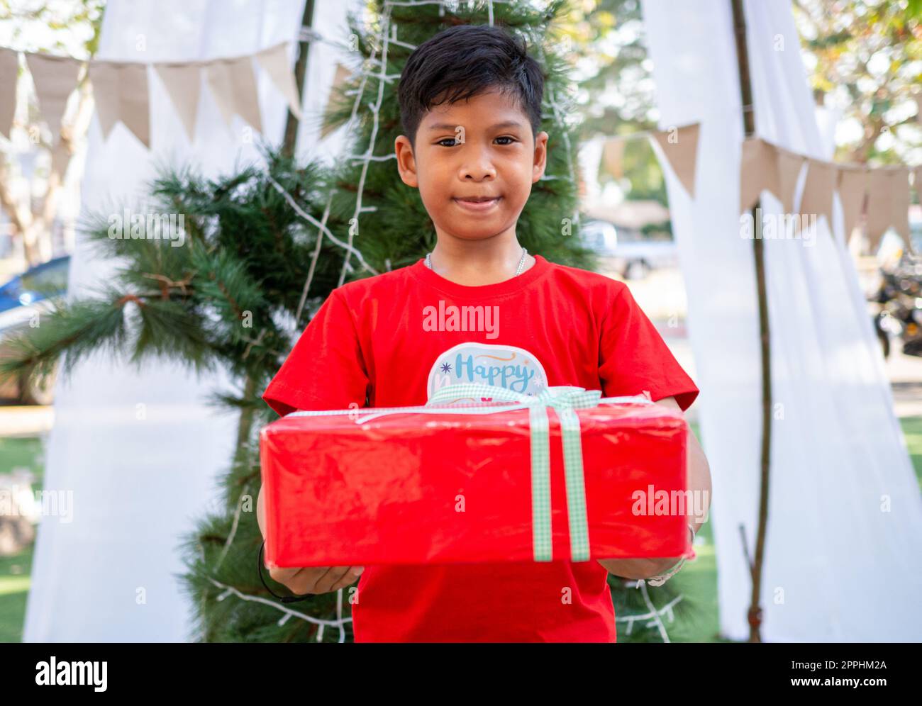 Ein Junge mit Geschenken zur Weihnachtsfeier. Weihnachtsfestival. Stockfoto
