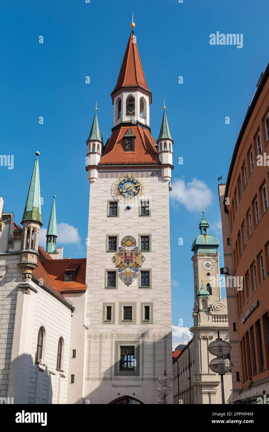 Der Turm des „Alten Rathauses“ im historischen Stadtzentrum von München bei sonnigem Sommerwetter und blauem Himmel mit dem Turm der „Heiligen Geisterkirche“ im Hintergrund Stockfoto