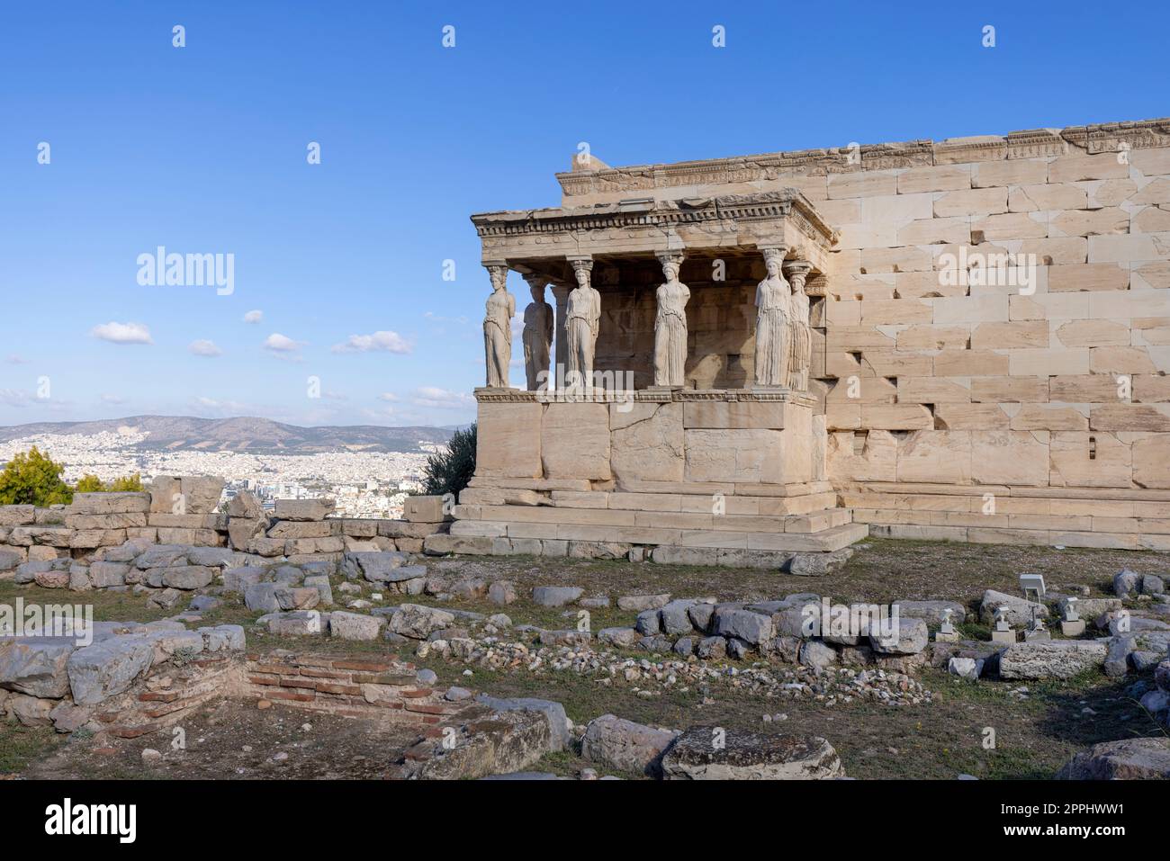 Erechtheion, Tempel der Athena Polias auf der Akropolis von Athen, Griechenland. Blick auf die Veranda der Jungfrauen mit Statuen der Kariatiden. Luftaufnahme der Stadt in der Ferne Stockfoto